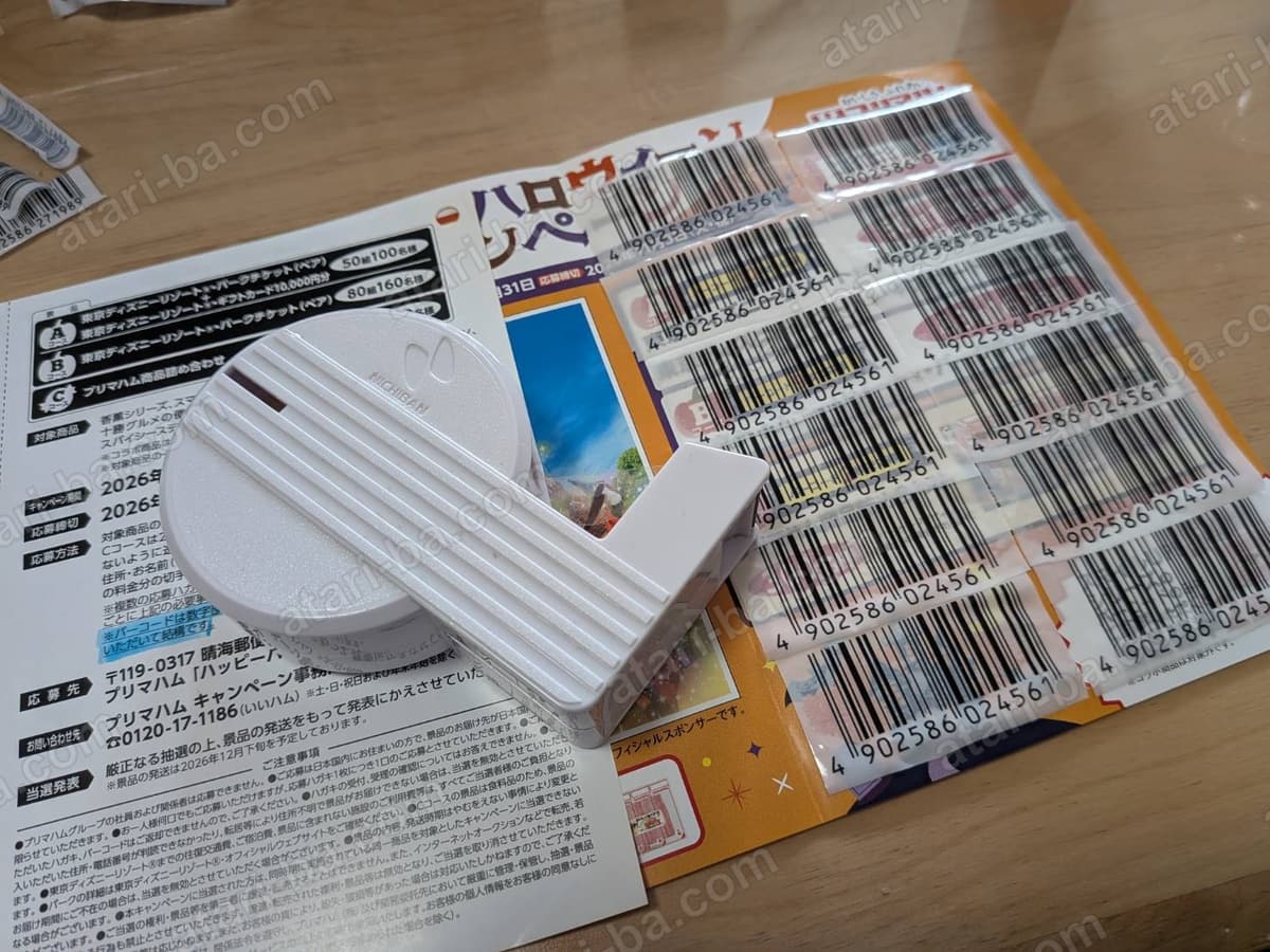 テープカッターと、12枚のバーコードを貼り終えた貼付面。バーコードの上に透明なテープが重ねて貼られている